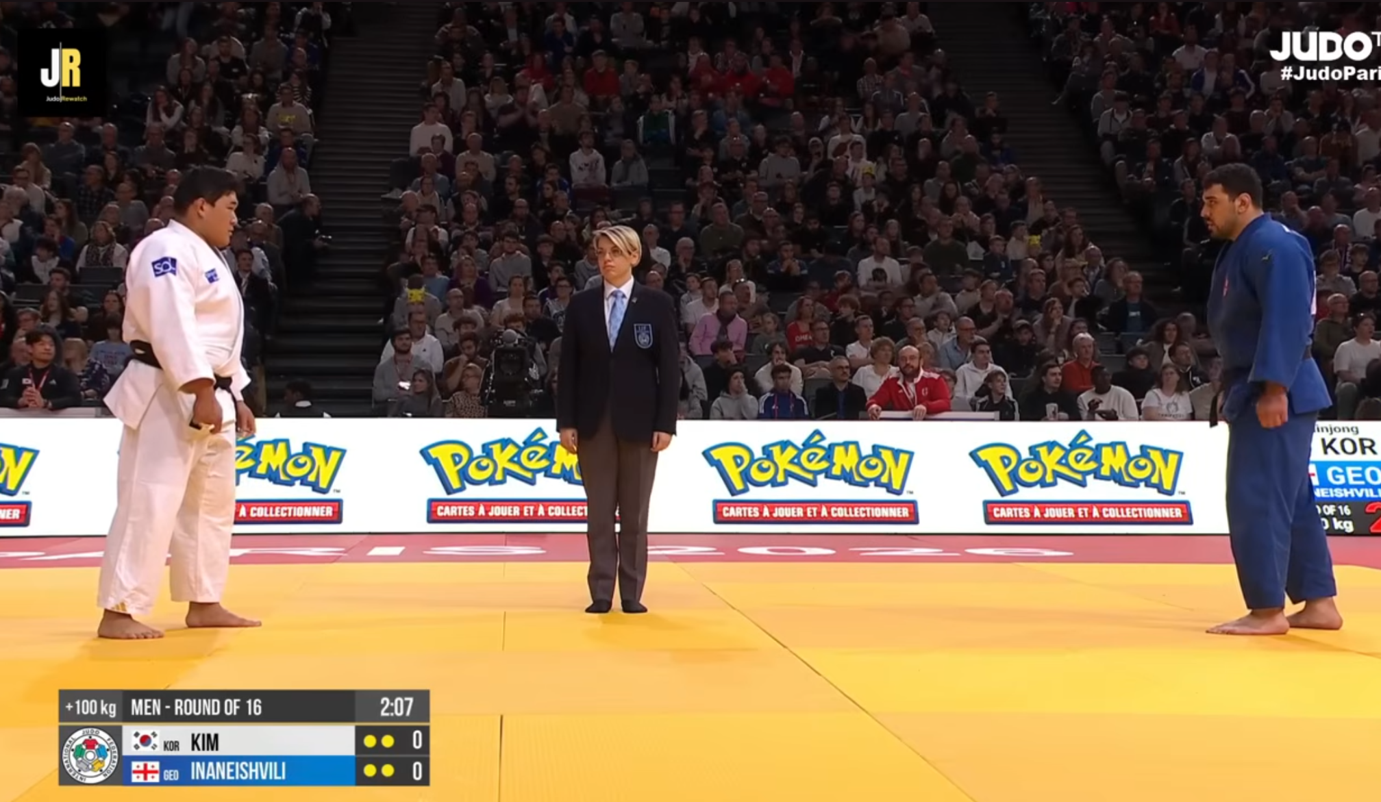 Judoka standing in front of a wall with Pokémon ads